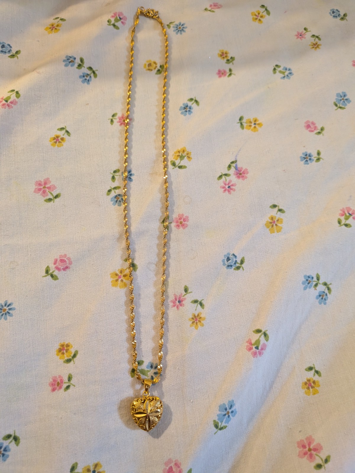 This gold-toned necklace , floral-embossed heart locket In twisted rope chain.