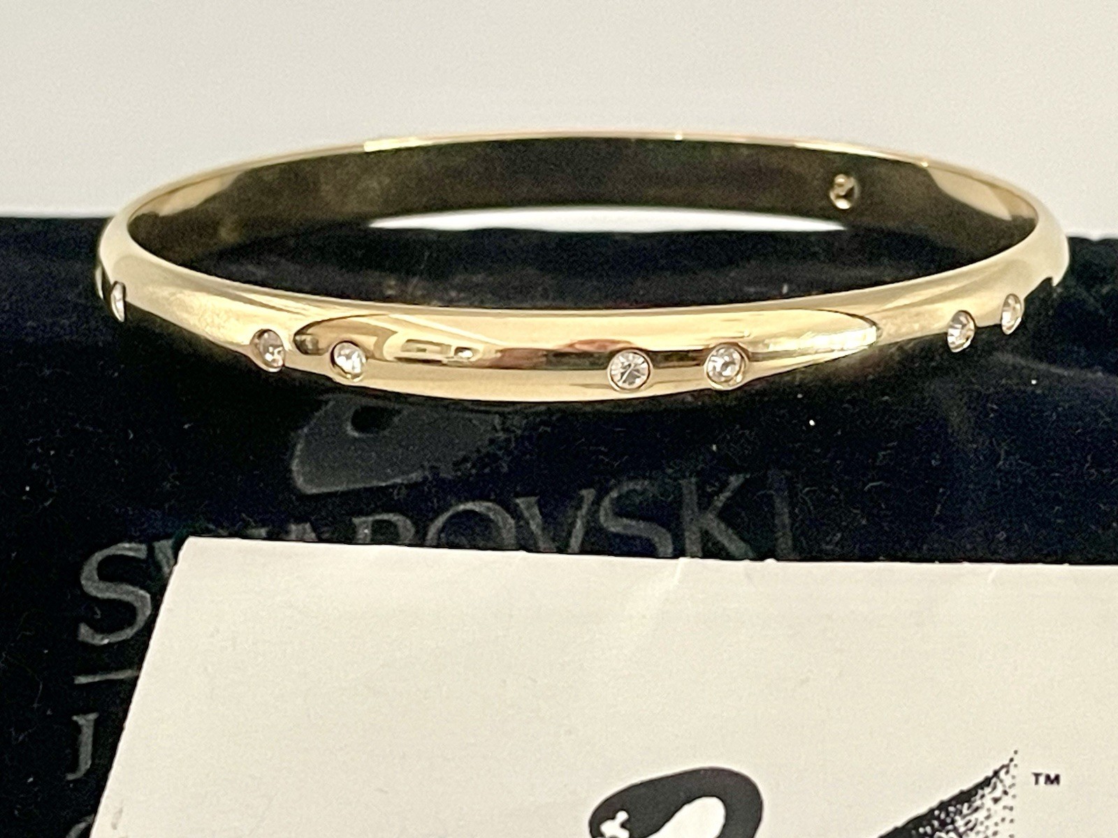 Swarovski Gold Tone Bangle Bracelet with Scattered Crystal Accents Swan Logo