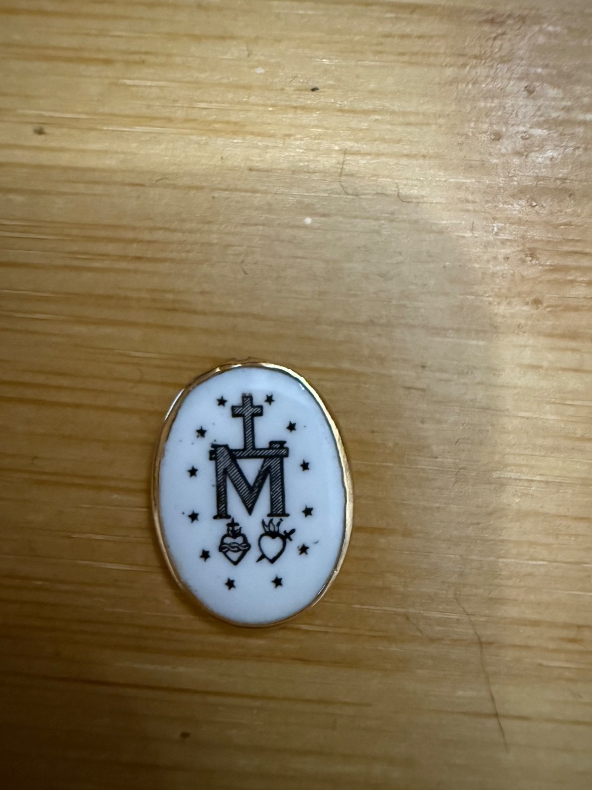 This 14K yellow gold Miraculous Medal features a hand-painted porcelain