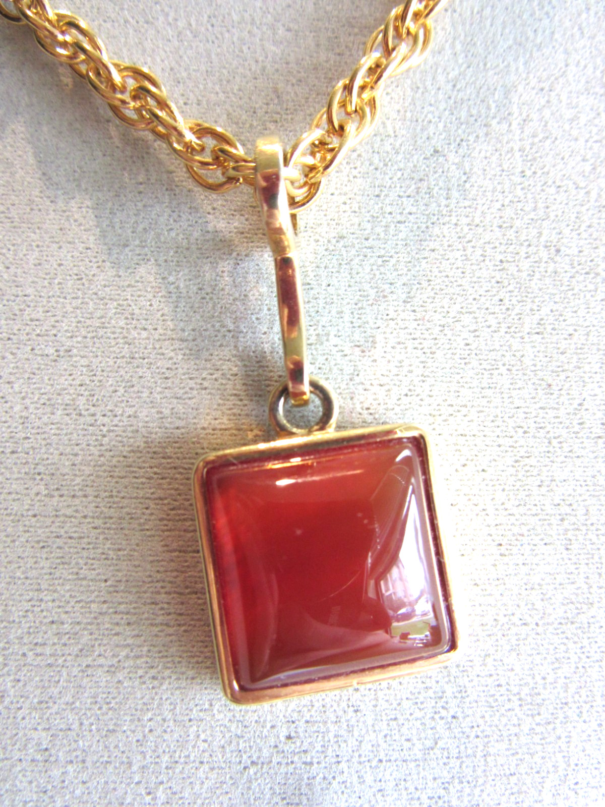 Gold tone rope chain necklace with Roman brand carnelian pendant