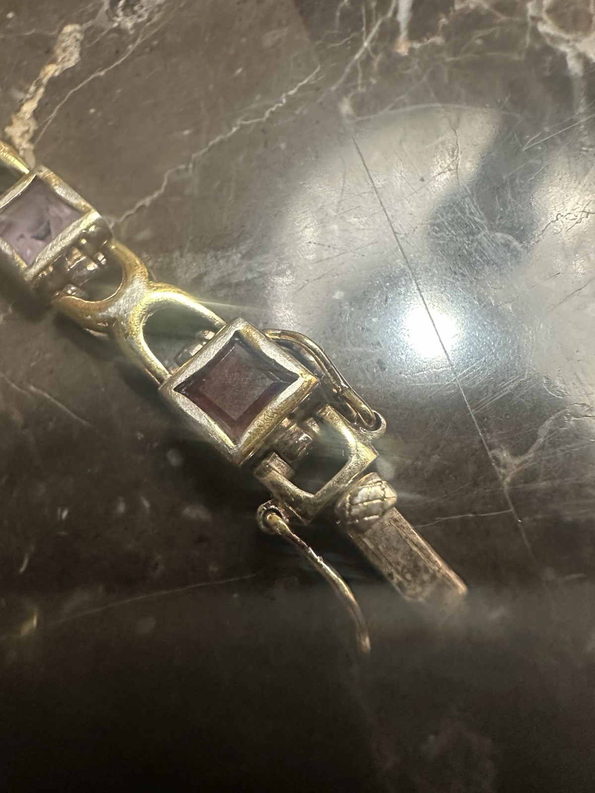Gold Plated link bracelet with assorted square gemstones and a bezel box clasp.
