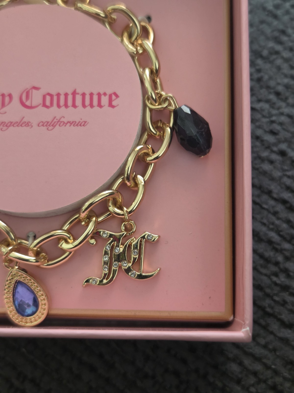 Juicy Couture Gold Charm Bracelet with Blue and Black Accents