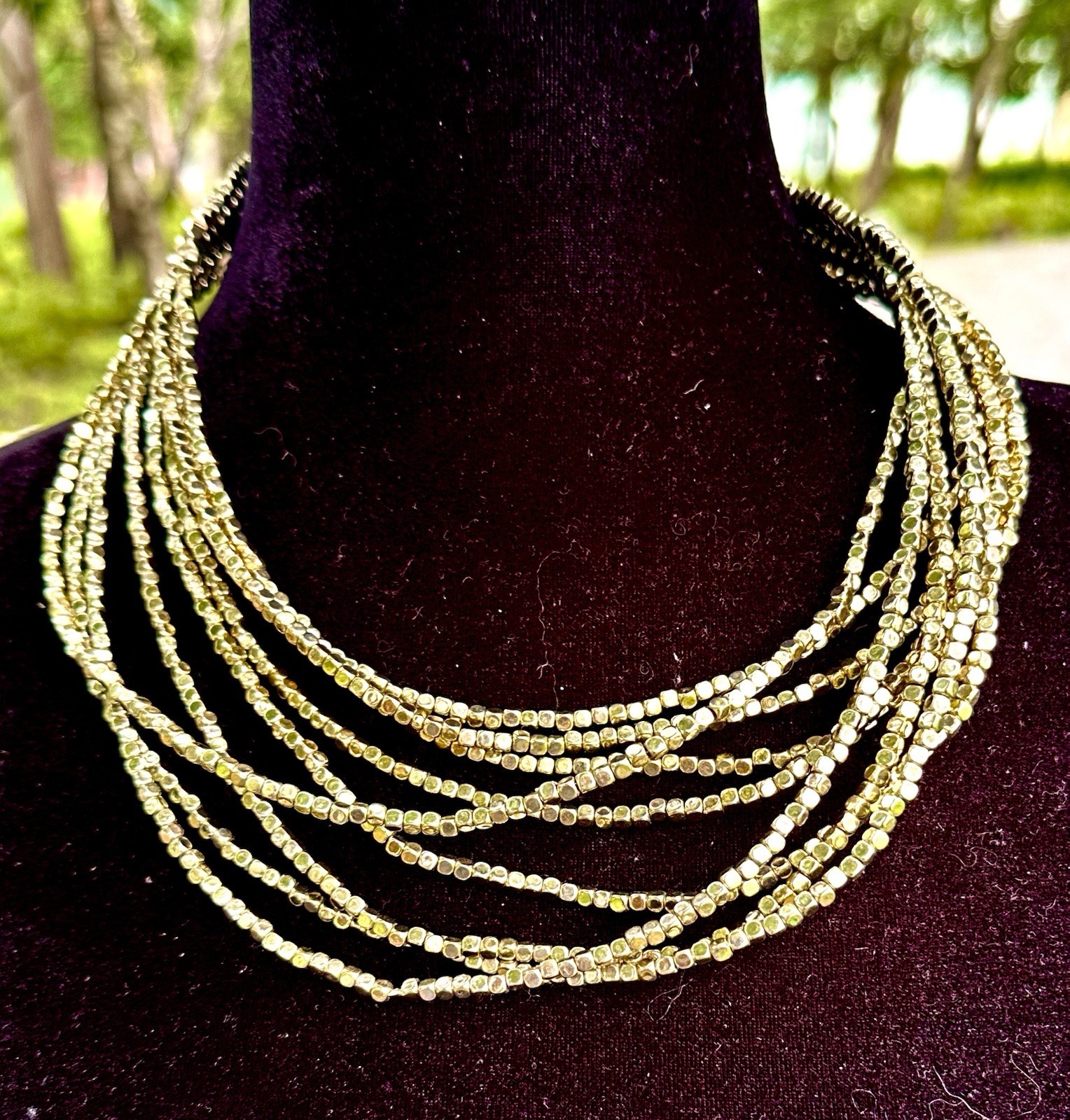 multi-strand bib necklace appears to be crafted from metallic-plated hematite