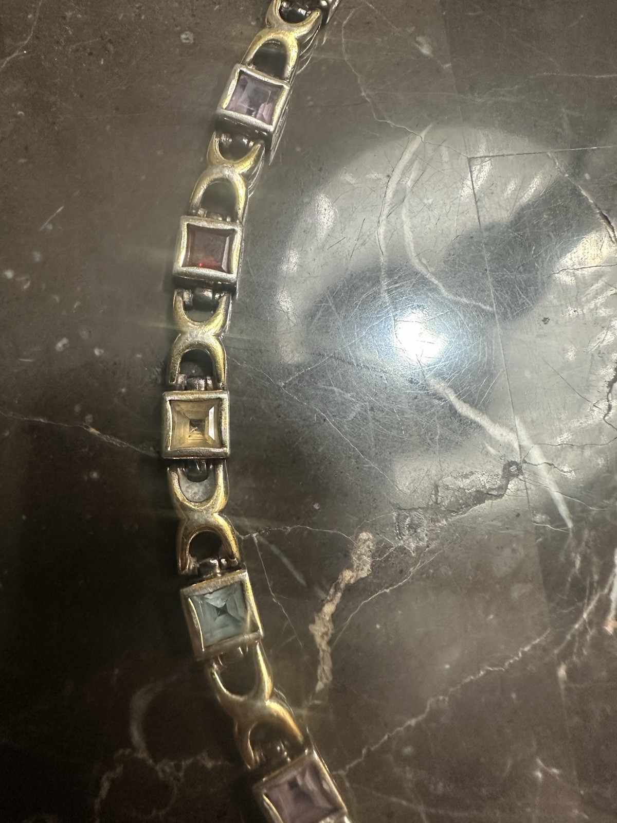 Gold Plated link bracelet with assorted square gemstones and a bezel box clasp.