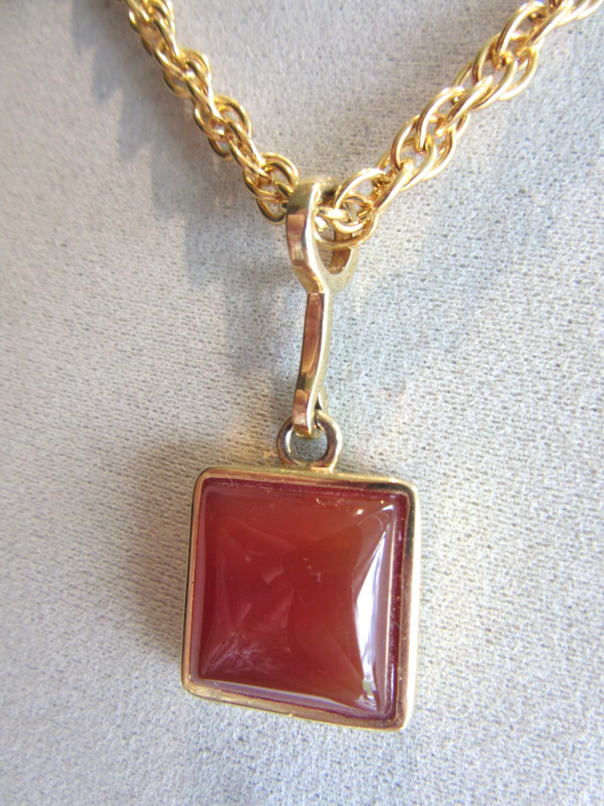 Gold tone rope chain necklace with Roman brand carnelian pendant