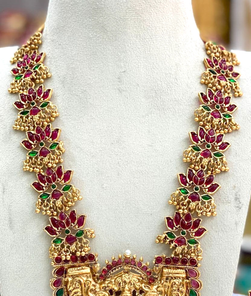 Traditional gold-tone necklace set features lotus motifs and a Goddess Lakshmi