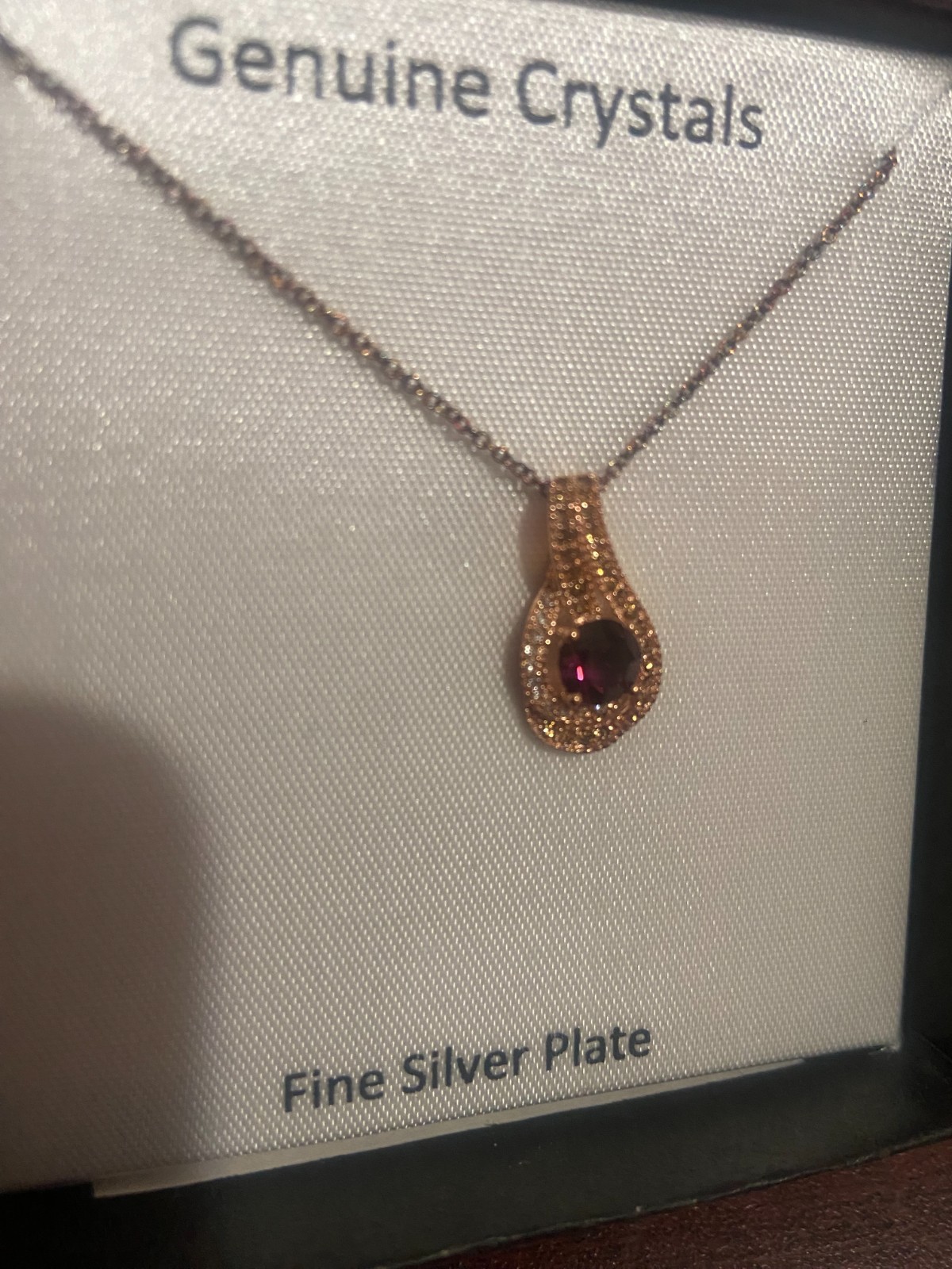 Gold Women’s Necklace with purple gemstone.