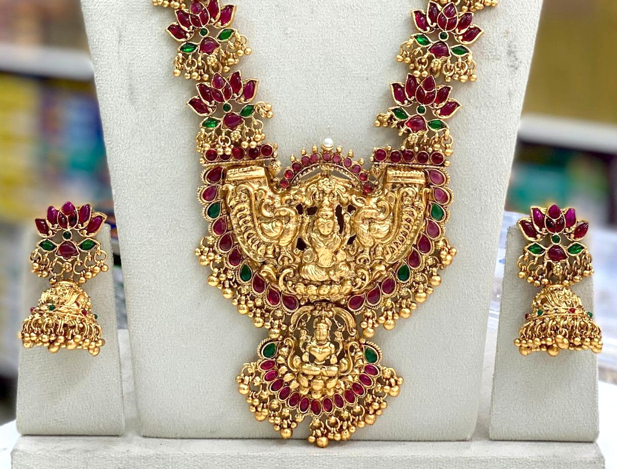 Traditional gold-tone necklace set features lotus motifs and a Goddess Lakshmi