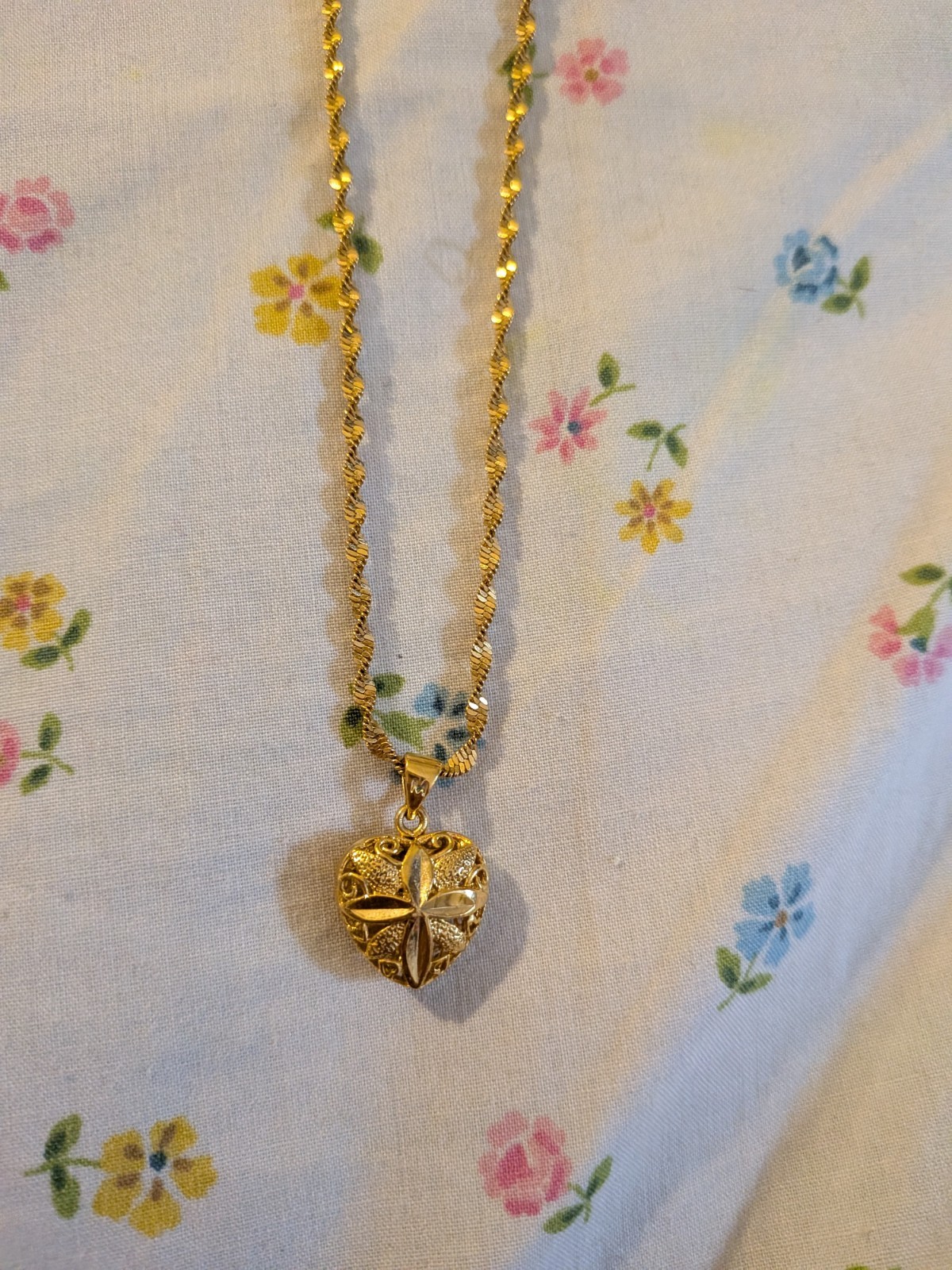 This gold-toned necklace , floral-embossed heart locket In twisted rope chain.