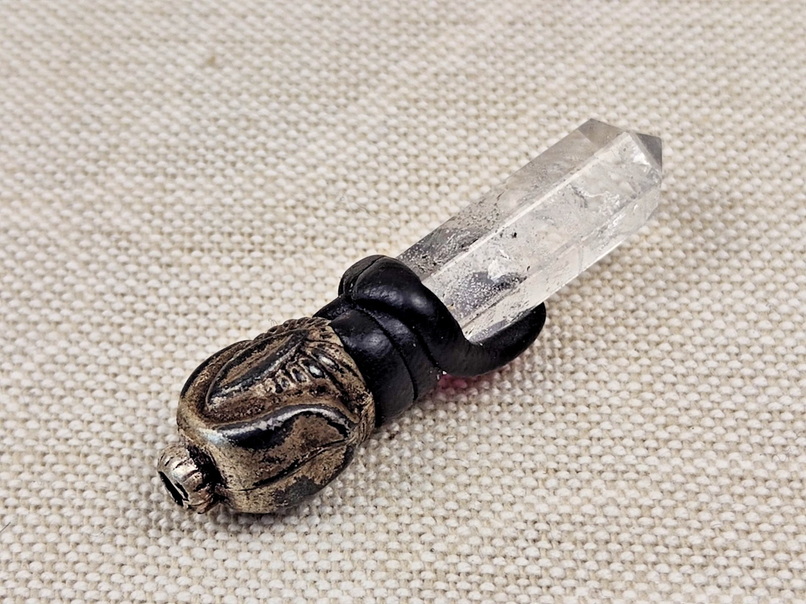 A pendant or talisman made of rock crystal and accented with a rose-red stone