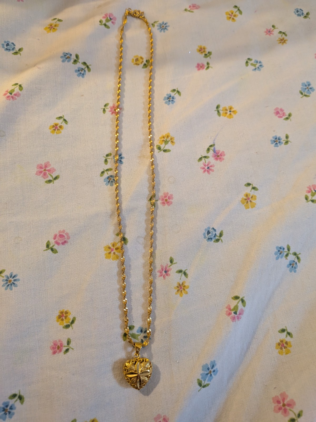 This gold-toned necklace , floral-embossed heart locket In twisted rope chain.