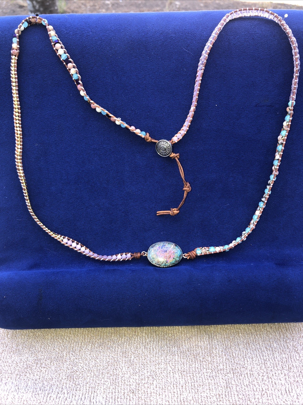 A 37” long necklace ,￼￼ a Bohemian or Hippie emphasizing made of leather, gems.w