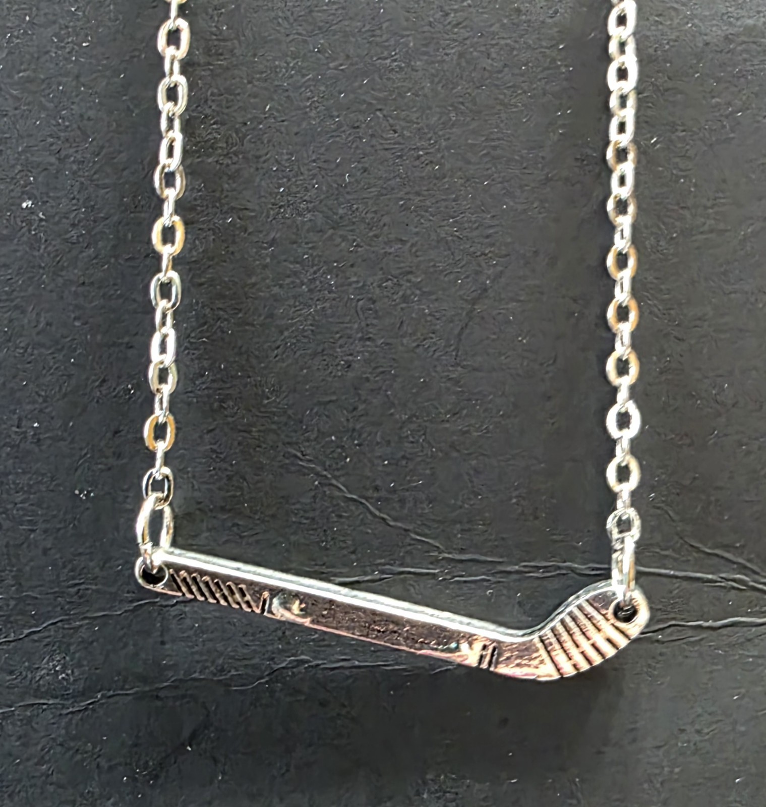 Silver Toned Hockey Stick necklace. 18″ w/ 2.5″ extender