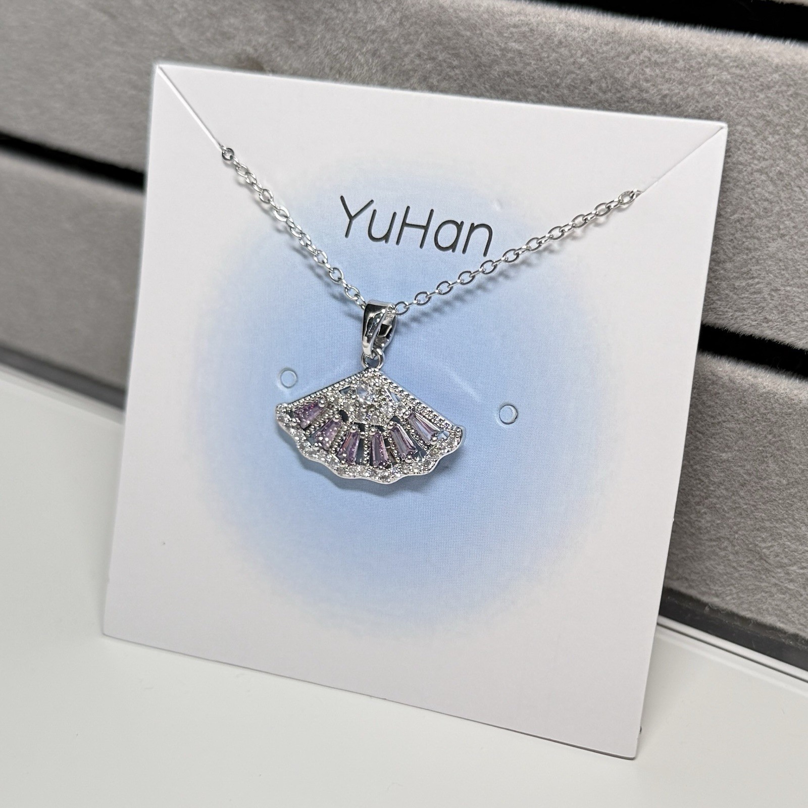 Purple rhinestone fan-shaped pendant with 18″ adjustable length necklace.